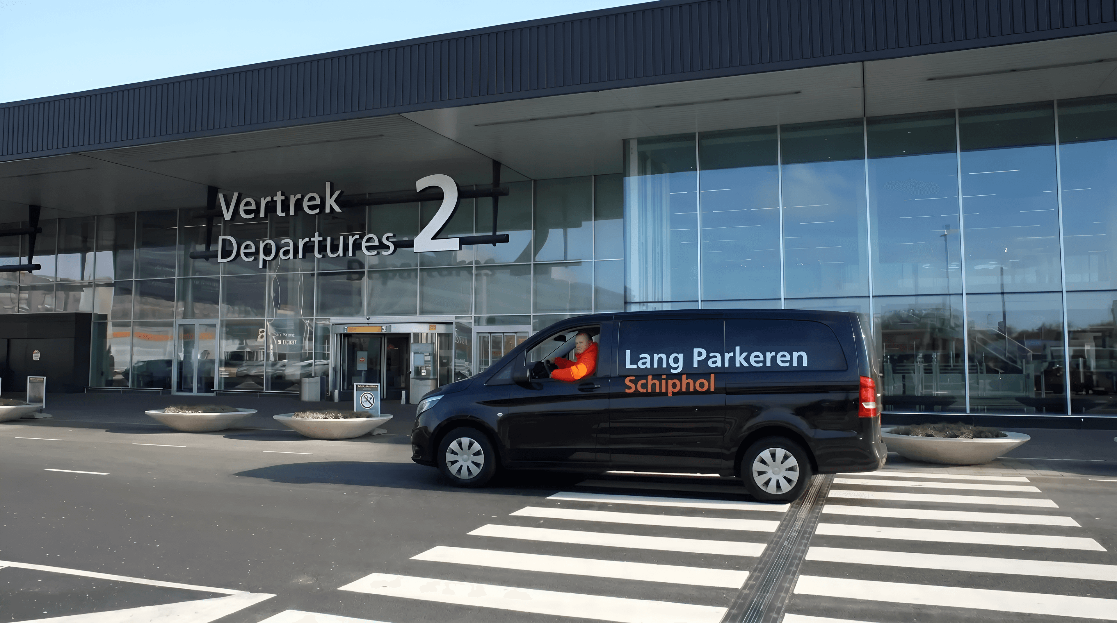 Shuttlebus van Lang Parkeren Schiphol bij de ingang Vertrek 2 van de vertrekhal op Schiphol.